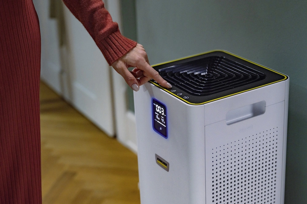 Hand einer Person bedient einen Kärcher Luftreiniger